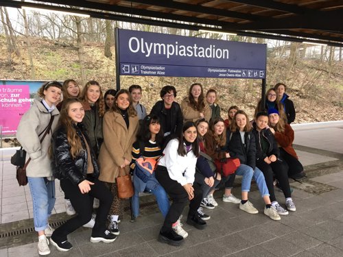 A group of students on a German educational trip in front of the "Olympiastadion" sign in Berlin.