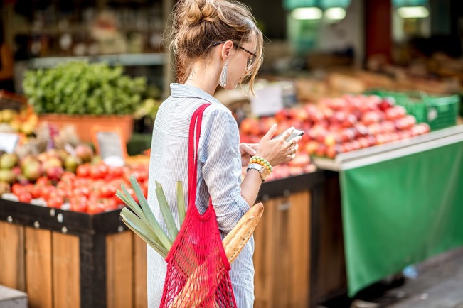 A student on a French language educational trip walking past a French food market.